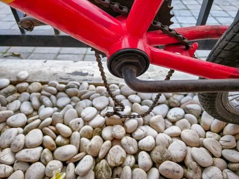 Broken rusty bicycle chain with red frame Stock Photos
