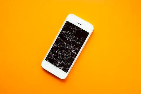 Broken screen of smartphone on the orange background Stock Photos