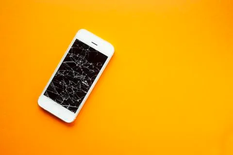 Broken screen of smartphone on the orange background Stock Photos