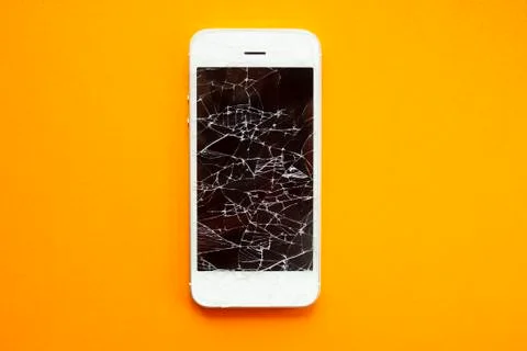 Broken screen of smartphone on the orange background Stock Photos