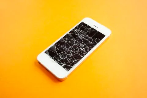 Broken screen of smartphone on the orange background Stock Photos