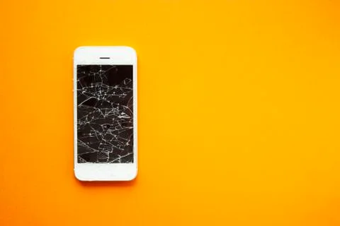 Broken screen of smartphone on the orange background Stock Photos