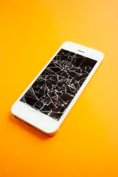 Broken screen of smartphone on the orange background Stock Photos