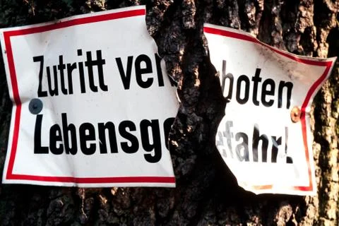 Broken sign on tree trunk Stock Photos