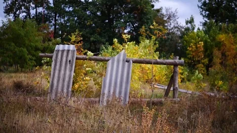 Broken slate fence with holes. Through it you can see the trees. Stock Footage 95590553