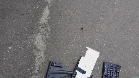 Broken into small pieces keyboard lying on the pavement .slow motion Video stock 76915337