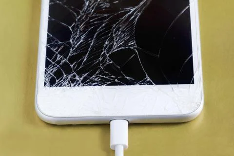 Broken smartphone with the cable connected. Preserving data before repairing  Stock-Fotos