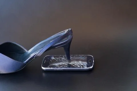 Broken smartphone with a shoe Stock Photos