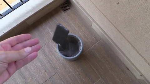 Broken smartphone is thrown into the trash can. slow motion. Stock Footage 79193959