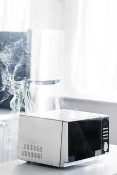 Broken steamy microwave table kitchen Stock Photos