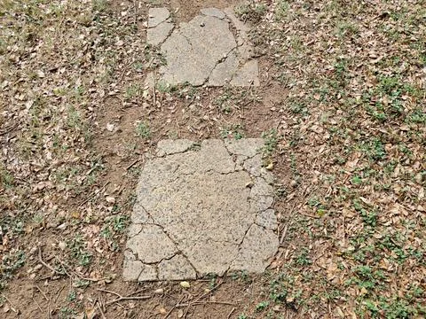 Broken stepping stones in path in the grass Stock Photos