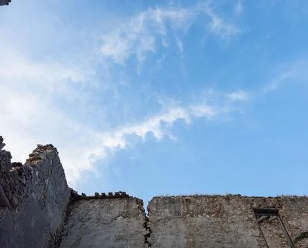 Broken stone structures frame blue sky with light clouds in historic setting Foto stock