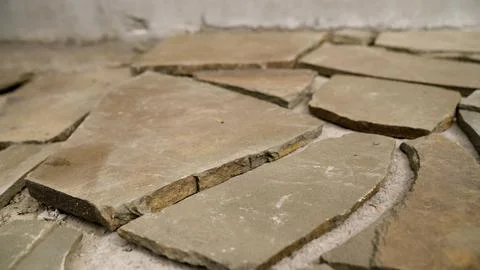Broken stone tiles on ground with rough texture and natural earth tones Fotos Stock