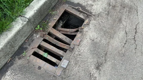 Broken Storm Drain Grate on Roadside Curb | Damaged Rusty Sewer Grille Stock Footage 343800042