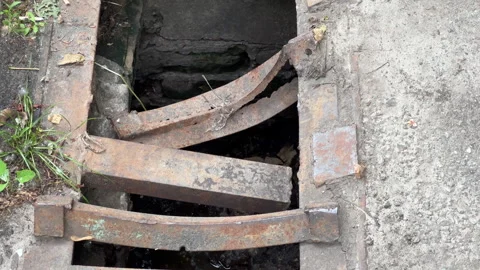 Broken Storm Drain Grate with Rusty Metal Bars | Camera Panning Along Damaged Stock Footage 345544993