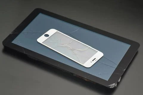 Broken tablet and broken protective glass from a smartphone, close-up Stock Photos