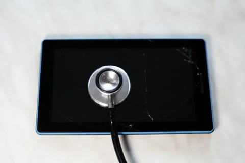 Broken tablet tapped with a stethoscope Foto stock
