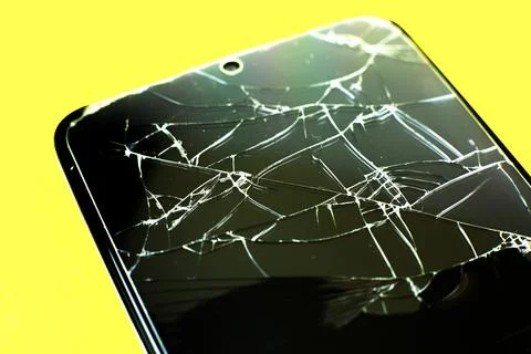 Broken tempered glass screen protector. Crashed smartphone. Close up. Stock Photos