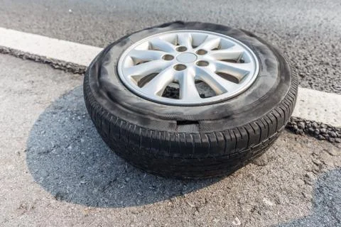 Broken tire damaged on surface putting on edge of road Foto stock