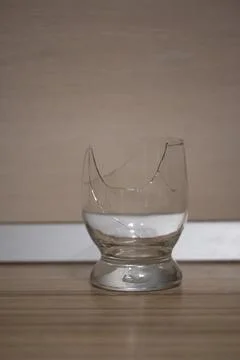 Broken transparent drinking glass in the kitchen Stock Photos