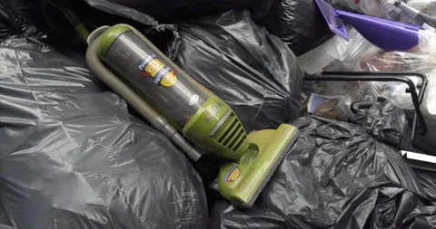 Broken Vacuum on top of Piles of black trash / waste bags. 4K Stock Footage 164575655