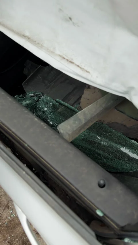 Broken vehicle windshield with shattered safety glass and damaged trim in close Stock Footage 345763788