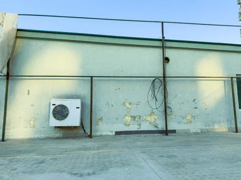 Broken wall and air conditioning unit on a roof during daylight Stock Photos