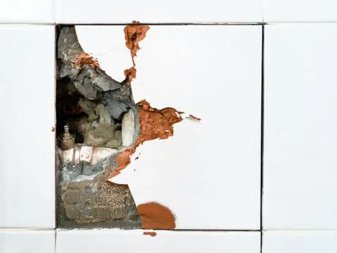 Broken wall tile and old closed ball valve closeup Stock Photos