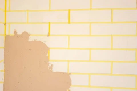 Broken wall with yellow brick pattern and peeling paint Stock Photos