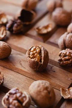 Broken walnuts on a wooden background. split nuts near the nutcracker Stockfoto's