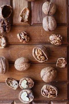 Broken walnuts on a wooden background. split nuts near the nutcracker Stockfoto's