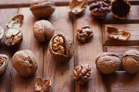 Broken walnuts on a wooden background. split nuts near the nutcracker Foto stock