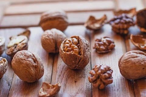 Broken walnuts on a wooden background. split nuts near the nutcracker Stock Photos