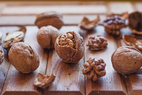 Broken walnuts on a wooden background. split nuts near the nutcracker Stockfoto's