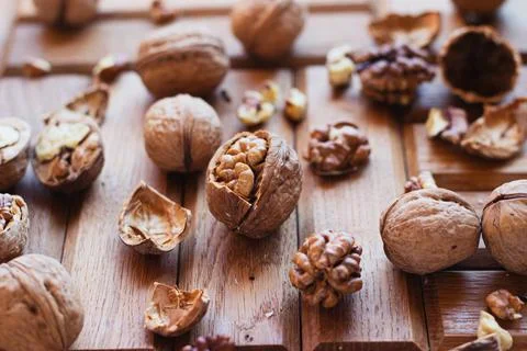 Broken walnuts on a wooden background. split nuts near the nutcracker Foto stock