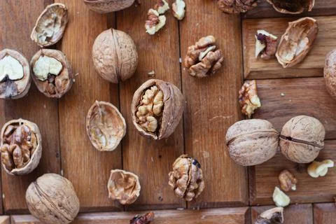 Broken walnuts on a wooden background. split nuts near the nutcracker Stockfoto's