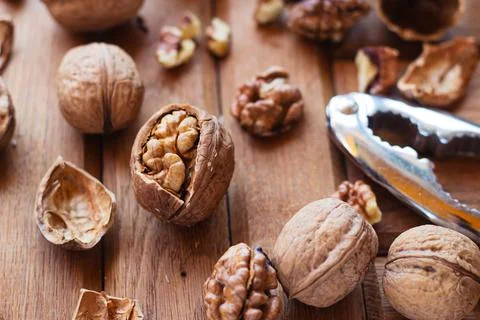 Broken walnuts on a wooden background. split nuts near the nutcracker Foto stock