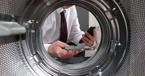 Broken washing machine. a man in a suit speaks through his smartphone about a Stock-Footage 152855567