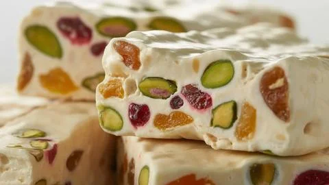 Broken white chocolate chunks with dried fruits and nuts on floral cloth Stock Photos