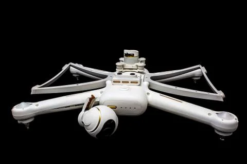 Broken white drone after a fall. Isolated on a black background. Damaged body Stock Photos