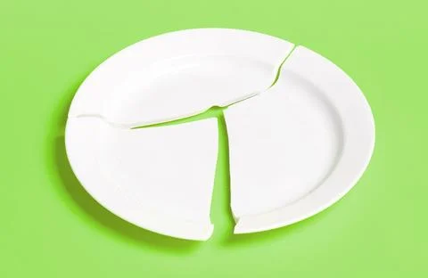 Broken white plate on a solid background Stock Photos