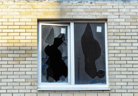 Broken window on an abandoned construction site after developer bankruptcy Stockfoto's