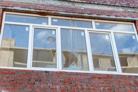 Broken window on an abandoned construction site after developer bankruptcy Stock Photos