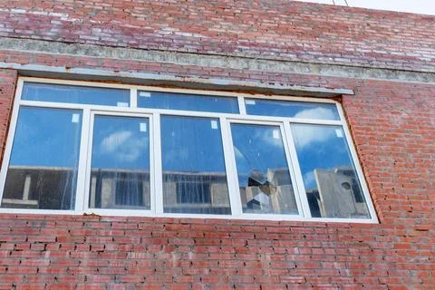 Broken window on an abandoned construction site after developer bankruptcy 库存照片