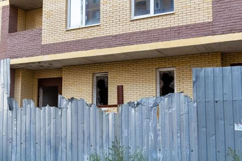 Broken window on an abandoned construction site after developer bankruptcy Stockfoto's