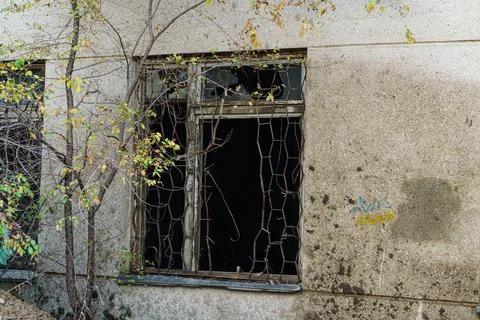 Broken window with broken bars on the wall Stock Photos