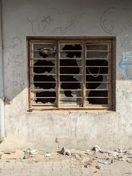 Broken window in dilapidated building with graffiti Stock Photos