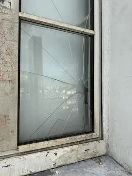 Broken window glass with visible cracks in an industrial setting illustrati.. Stock Photos