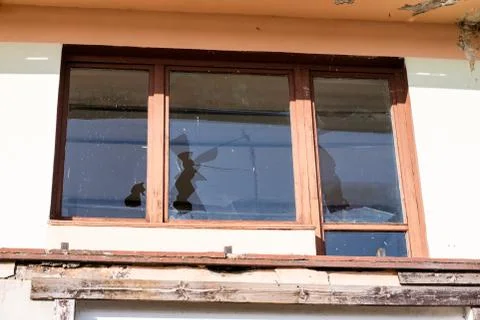 A broken window in an old abandoned building. Broken glass on the window site Fotos de archivo