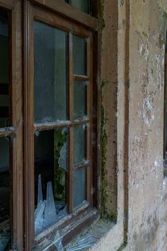 Broken window in old abandoned building exterior Stock Photos